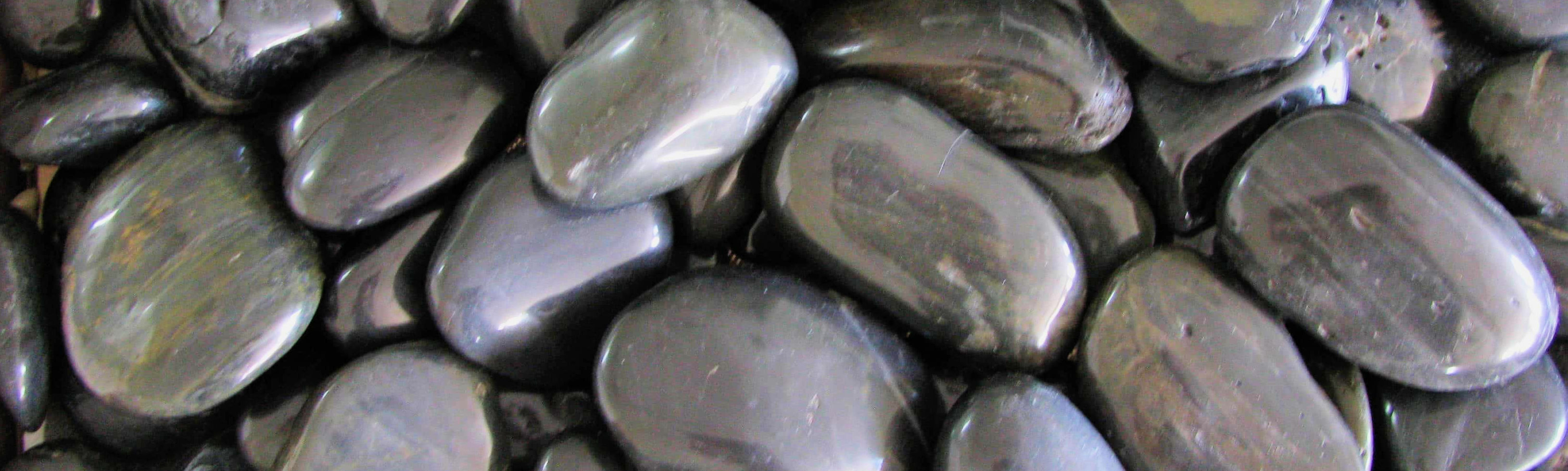 Showing a closeup of Polished Black Pebbles